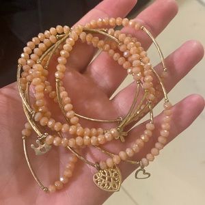 This is a charm bracelet with rose quartz colored beads